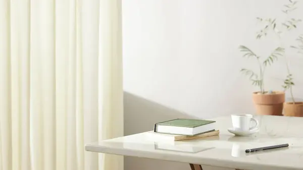 Bu odada doğal ışık ile sakin bir atmosfer var. Masada kil kaplar, cam şişeler, kahve ve çeşitli maddeler var..