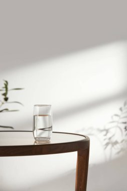 Bu odada doğal ışık ile sakin bir atmosfer var. Masada kil kaplar, cam şişeler, kahve ve çeşitli maddeler var..