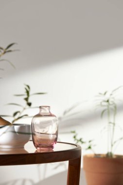 Bu odada doğal ışık ile sakin bir atmosfer var. Masada kil kaplar, cam şişeler, kahve ve çeşitli maddeler var..