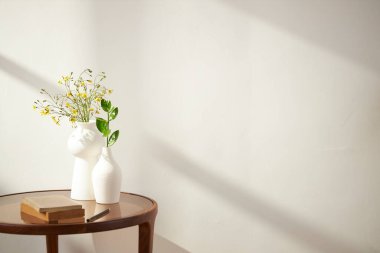 Vazolar ve eşyalar sıcak bir odada masanın üstünde.