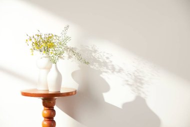 Vazolar ve eşyalar sıcak bir odada masanın üstünde.