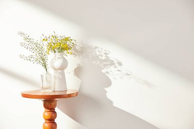 Vazolar ve eşyalar sıcak bir odada masanın üstünde.