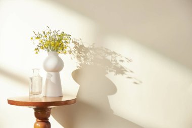 Vazolar ve eşyalar sıcak bir odada masanın üstünde.