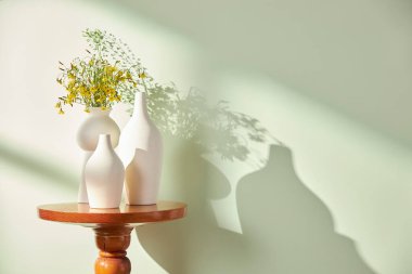 Vazolar ve eşyalar sıcak bir odada masanın üstünde.