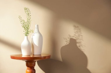 Vazolar ve eşyalar sıcak bir odada masanın üstünde.