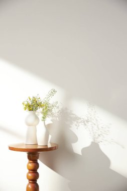 Vazolar ve eşyalar sıcak bir odada masanın üstünde.