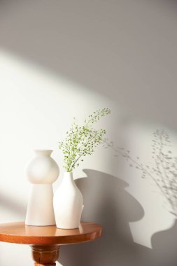 Vazolar ve eşyalar sıcak bir odada masanın üstünde.