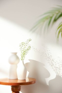 Vazolar ve eşyalar sıcak bir odada masanın üstünde.