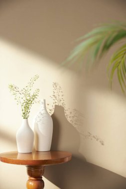 Vazolar ve eşyalar sıcak bir odada masanın üstünde.