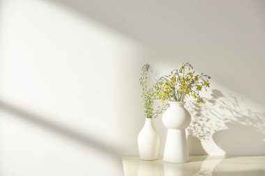 Vazolar ve eşyalar sıcak bir odada masanın üstünde.