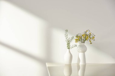 Vazolar ve eşyalar sıcak bir odada masanın üstünde.