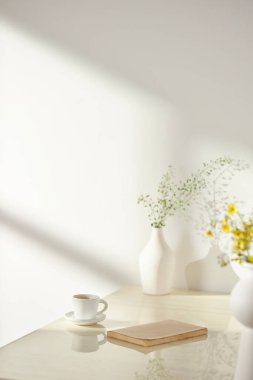 Vazolar ve eşyalar sıcak bir odada masanın üstünde.