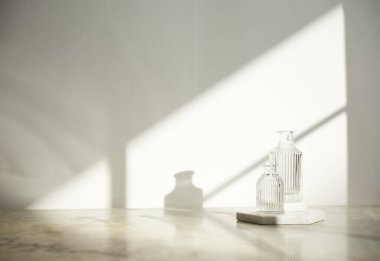 Ilık güneş ışığı, çimen yapraklarından gölgeler, masa üstünde vazo ve fincanlar gibi çeşitli nesnelerin olduğu bir oda.