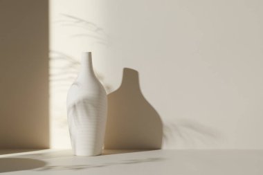 Ilık güneş ışığı, çimen yapraklarından gölgeler, masa üstünde vazo ve fincanlar gibi çeşitli nesnelerin olduğu bir oda.