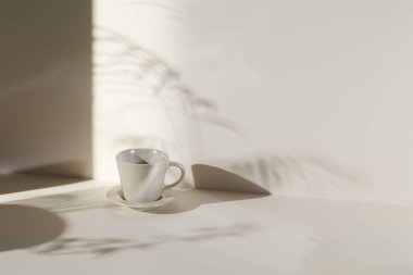 Ilık güneş ışığı, çimen yapraklarından gölgeler, masa üstünde vazo ve fincanlar gibi çeşitli nesnelerin olduğu bir oda.