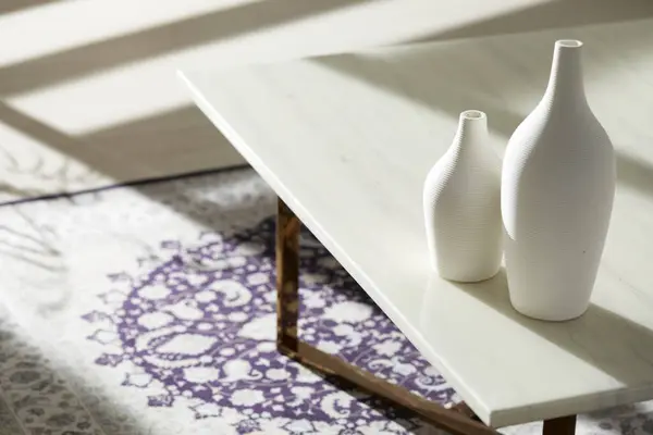 Vazolar ve eşyalar sıcak bir odada masanın üstünde.