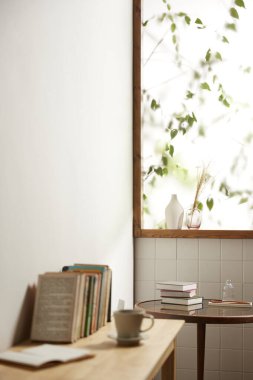 Sıcak bir öğleden sonra güneşinin, ağaç yaprakları manzaralı pencereden içeri girdiği rahat bir oda..