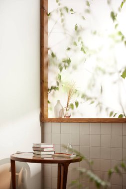 Sıcak bir öğleden sonra güneşinin, ağaç yaprakları manzaralı pencereden içeri girdiği rahat bir oda..