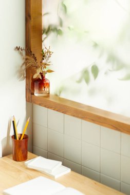 Sıcak bir öğleden sonra güneşinin, ağaç yaprakları manzaralı pencereden içeri girdiği rahat bir oda..