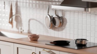 Parlak bej renkli bir mutfak. Pencereden içeri güneş ışığı giriyor..