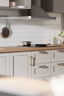 Parlak bej renkli bir mutfak. Pencereden içeri güneş ışığı giriyor..