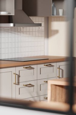 Parlak bej renkli bir mutfak. Pencereden içeri güneş ışığı giriyor..