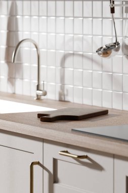 Parlak bej renkli bir mutfak. Pencereden içeri güneş ışığı giriyor..