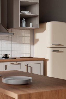 Parlak bej renkli bir mutfak. Pencereden içeri güneş ışığı giriyor..