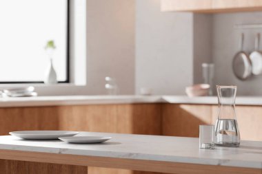 Parlak bej renkli bir mutfak. Pencereden içeri güneş ışığı giriyor..