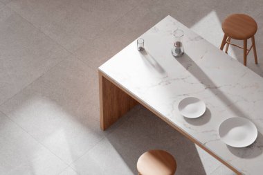 Parlak bej renkli bir mutfak. Pencereden içeri güneş ışığı giriyor..