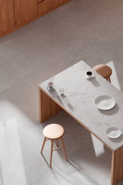 Parlak bej renkli bir mutfak. Pencereden içeri güneş ışığı giriyor..