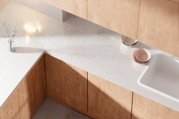 Parlak bej renkli bir mutfak. Pencereden içeri güneş ışığı giriyor..