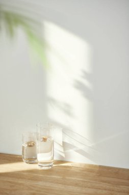 Bir su bardağı ve güneş ışığında bir masanın üzerindeki gölge..