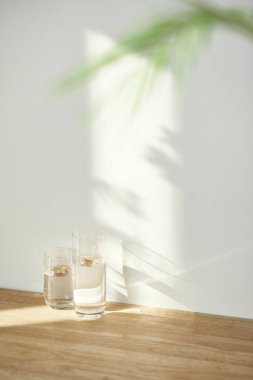 Bir su bardağı ve güneş ışığında bir masanın üzerindeki gölge..