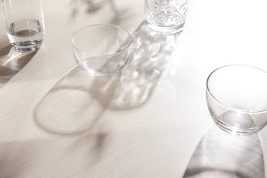 Masadaki çeşitli cam bardakların doğal dokusu ve güneş ışığı içeri doğru akıyor..