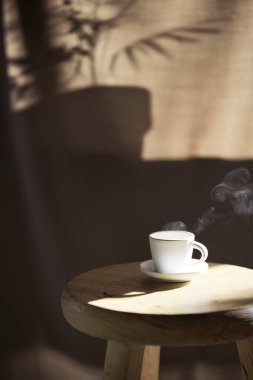 Arka planda gölgeler parlıyor. Pencereden içeri güneş ışığı giriyor..