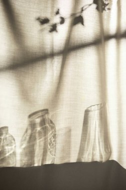 Arka planda gölgeler parlıyor. Pencereden içeri güneş ışığı giriyor..