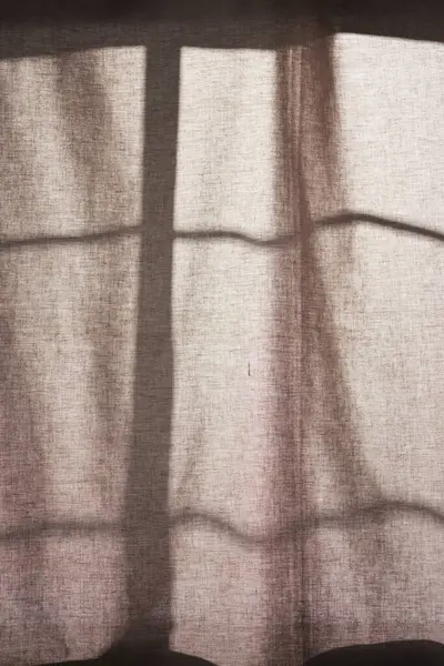 Arka planda gölgeler parlıyor. Pencereden içeri güneş ışığı giriyor..