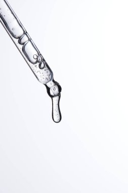 Kozmetik ve tıbbi görüntüler için kullanılabilen bir damlacıktan dökülen temiz sıvı damlacıklar.