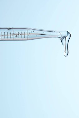 Kozmetik ve tıbbi görüntüler için kullanılabilen bir damlacıktan dökülen temiz sıvı damlacıklar.