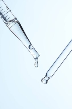 Kozmetik ve tıbbi görüntüler için kullanılabilen bir damlacıktan dökülen temiz sıvı damlacıklar.