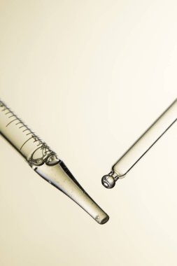 Kozmetik ve tıbbi görüntüler için kullanılabilen bir damlacıktan dökülen temiz sıvı damlacıklar.