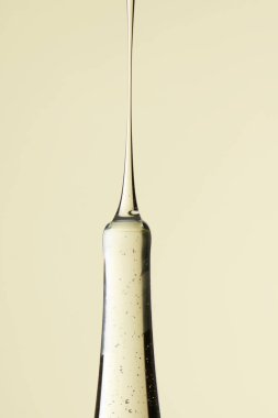 Kozmetik ve tıbbi görüntüler için kullanılabilen bir damlacıktan dökülen temiz sıvı damlacıklar.