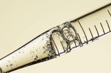 Kozmetik ve tıbbi görüntüler için kullanılabilen bir damlacıktan dökülen temiz sıvı damlacıklar.