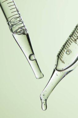 Kozmetik ve tıbbi görüntüler için kullanılabilen bir damlacıktan dökülen temiz sıvı damlacıklar.