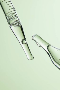 Kozmetik ve tıbbi görüntüler için kullanılabilen bir damlacıktan dökülen temiz sıvı damlacıklar.