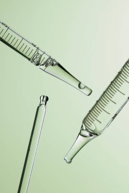 Kozmetik ve tıbbi görüntüler için kullanılabilen bir damlacıktan dökülen temiz sıvı damlacıklar.