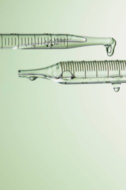 Kozmetik ve tıbbi görüntüler için kullanılabilen bir damlacıktan dökülen temiz sıvı damlacıklar.