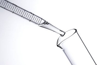 Kozmetik ve tıbbi görüntüler için kullanılabilen bir damlacıktan dökülen temiz sıvı damlacıklar.