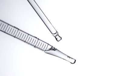 Kozmetik ve tıbbi görüntüler için kullanılabilen bir damlacıktan dökülen temiz sıvı damlacıklar.